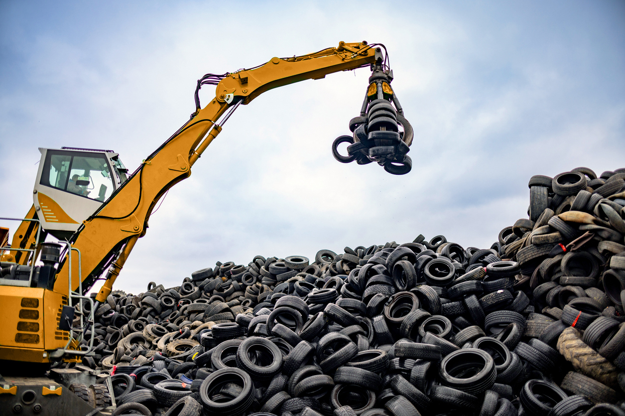 Modern material handler lifting and processing scrap tires